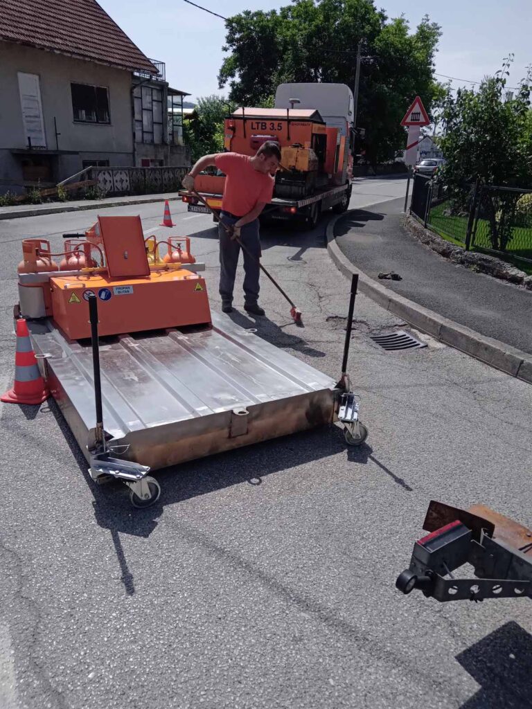 Oprava výtluku silnice pomocí infratechnologie. Úklid a nečistot.