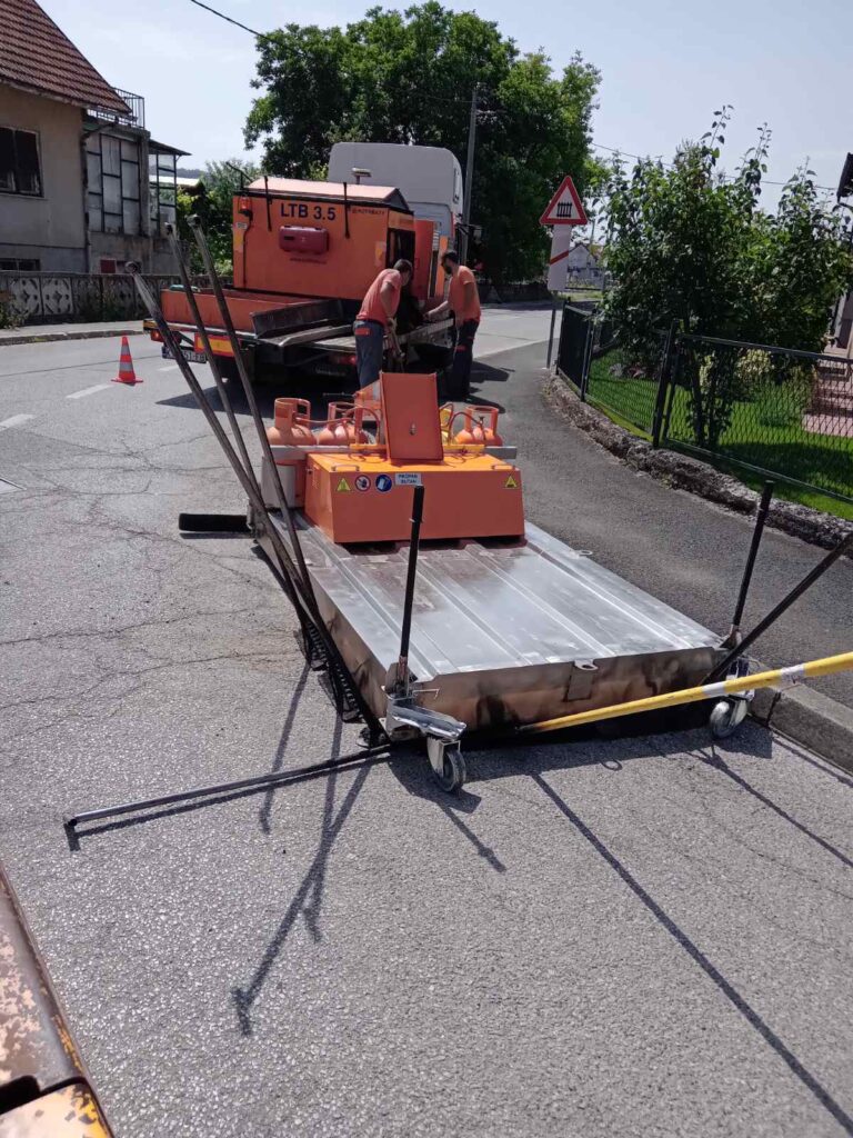 Oprava výtluku silnice pomocí infratechnologie. Nahřátí.
