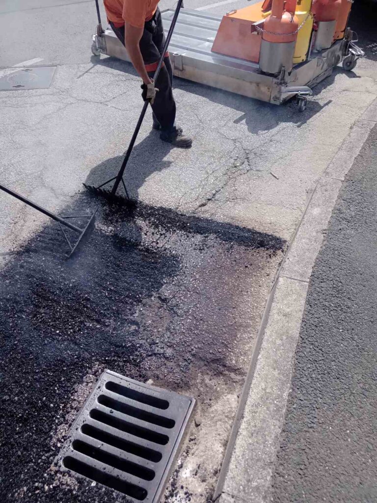 Oprava výtluku silnice pomocí infratechnologie. Přidání směsi recyklátu.