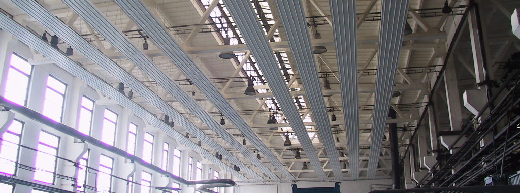 Vykurovanie priemyselných hál. Stropné sálavé panely inštalované v priemyselnej hale na úsporné vykurovanie.